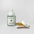 Two By Valenti skincare products including a dropper glass bottle and a jar on a light gray background