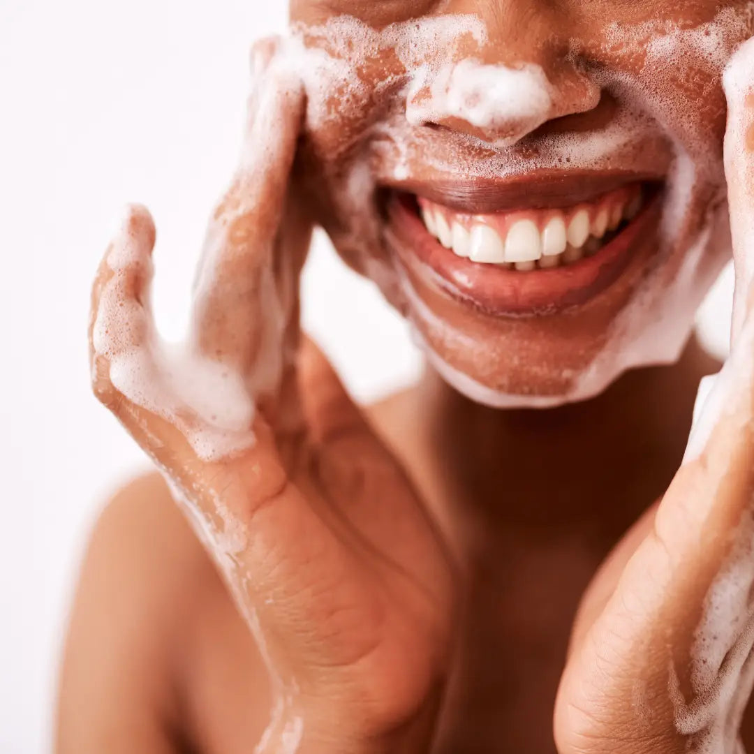 Woman washing her face with Black Clay Facial Bar Soap  from BY VALENTI and water