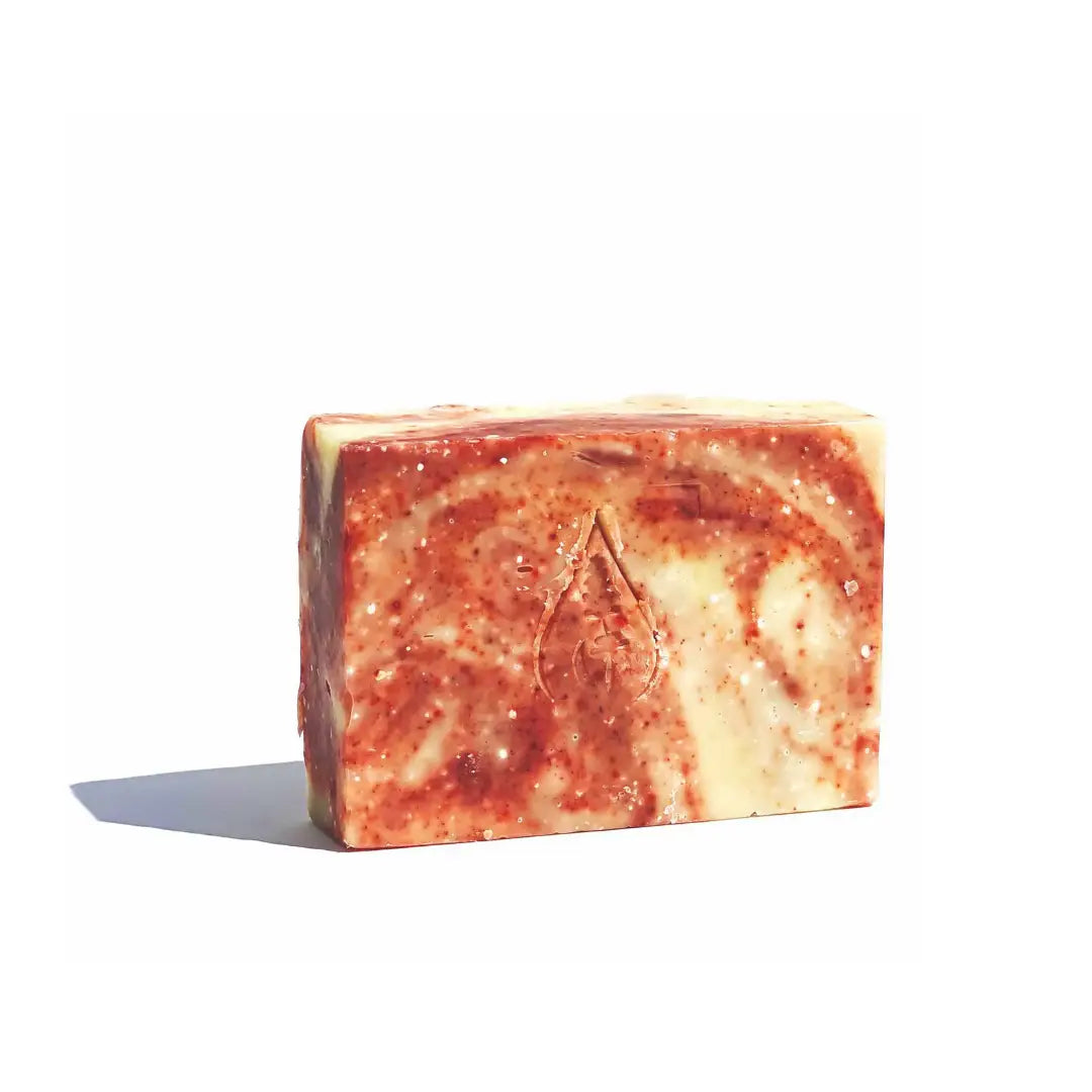 By Valenti marbled red and beige Himalayan Pink Salt Bar Soap with company's stamped logo on a white background