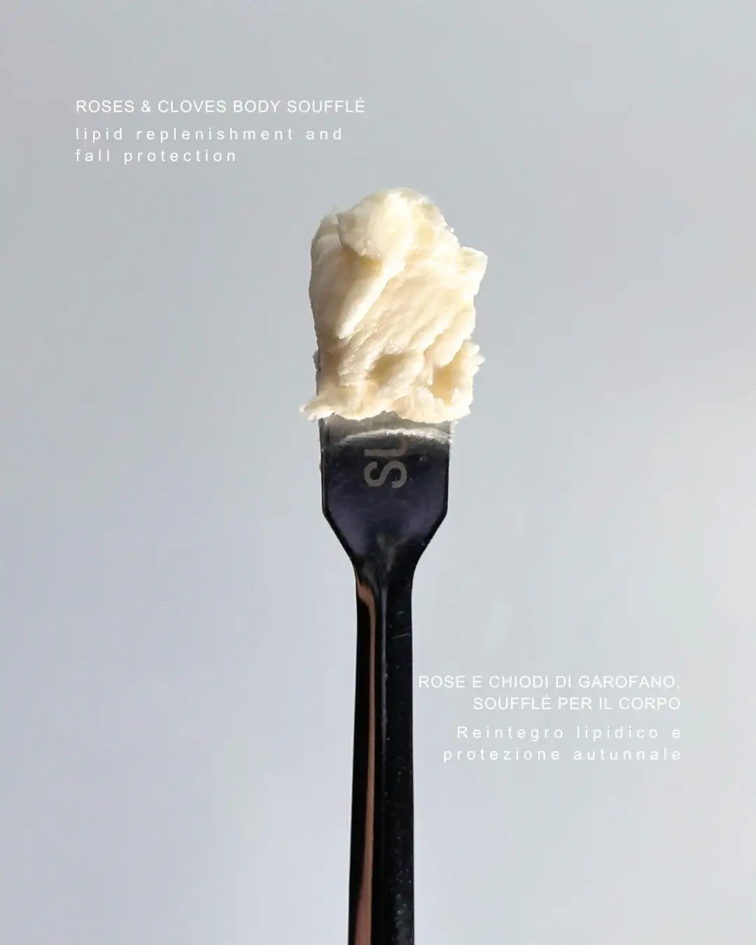 By Valenti whipped body butter on a lab spatula 'Roses & Clovers' branding on a gray background