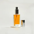By Valenti perfume bottle with orange perfume on a light gray background