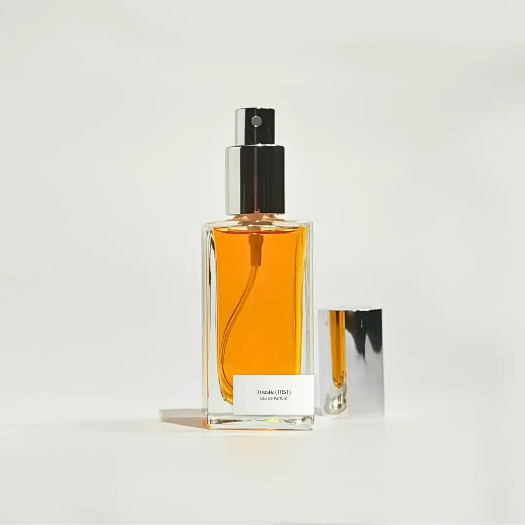 By Valenti perfume bottle with orange perfume on a light gray background