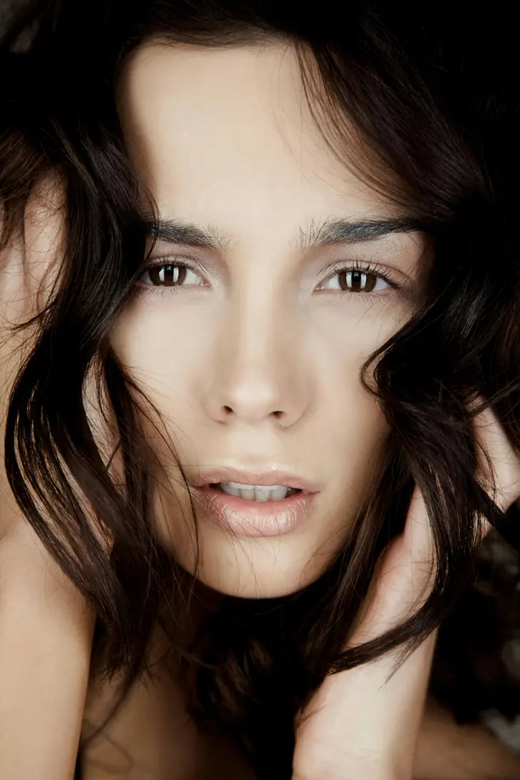 Close-up of a woman with dark hair and neutral expression